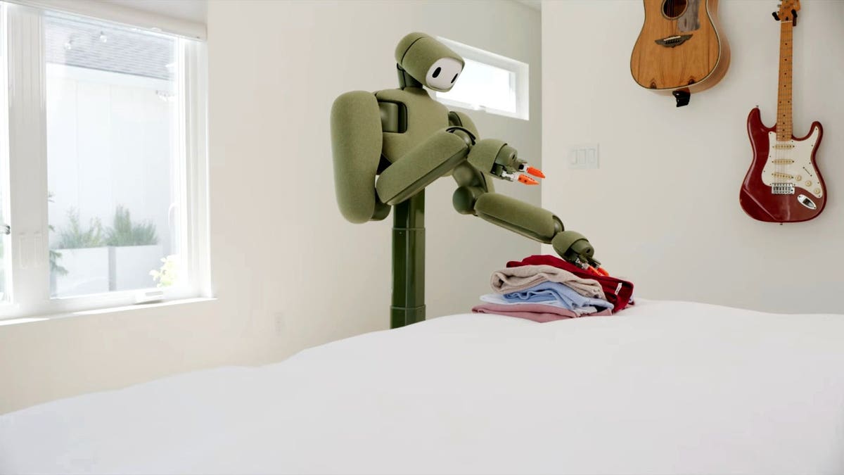Weave Robotics’ Isaac 1 home robot folds laundry on a bed.