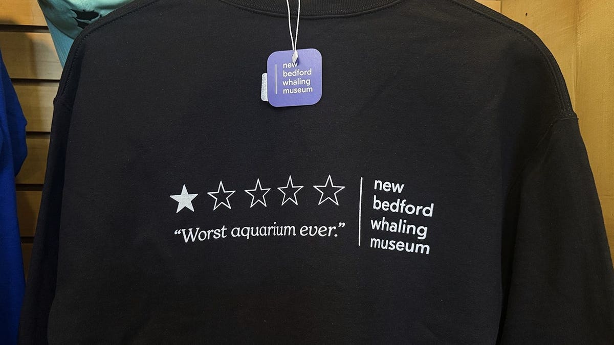Crewneck sweatshirt emblazoned with a viral one-star review displayed for sale.