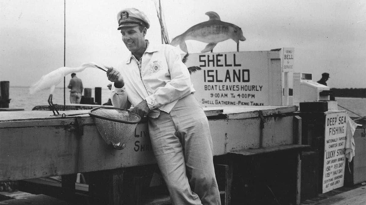 black and white photo of fishing captain standing on a dock