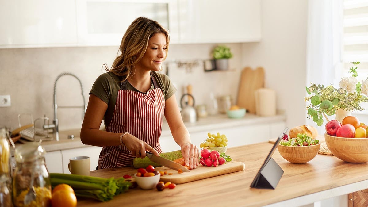 A woman cooks in a kitchen.