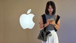 Woman looks at smartphone near Apple Store in China
