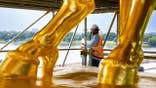 Worker removes scaffolding from regilded Arts of War statue in Washington, D.C.