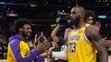 LeBron James and Bronny James interact during Lakers game