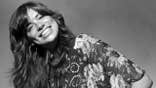Carly Simon smiling in a black and white photo.