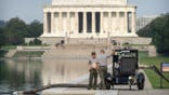 National Park Service workers stand near a pump placed next to the Lincoln Memorial Reflecting Pool