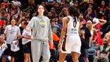 Caitlin Clark, who missed Thursday's game with injury, high fives Indiana Fever teammate Kelsey Mitchell during the game against the Phoenix Mercury.