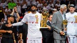 LeBron James holds up the Larry O'Brien Championship trophy.