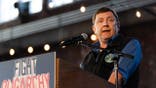 Troy Jackson speaking at a microphone during a political campaign event in Portland, Maine.
