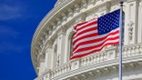 A United States flag in front of the Capitol.