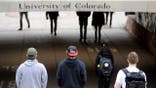 CU students walk under the University Hill bridge between classes.