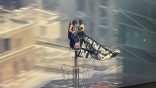 couple unfurling banner atop Empire State Building antenna