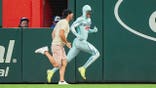 A fan races The Freeze on the field between innings at Truist Park.