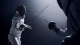 Two fencers dueling in a fencing sports match
