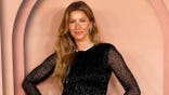 Gisele Bundchen poses in black dress