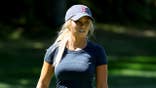 Hailey Ostrom walks onto the green during a pro-am at a golf course.