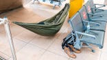 A man sleeps in a hammock inside Hamburg Airport terminal.