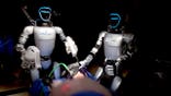 Two humanoid robots conduct a surgery.