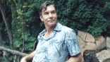 Jerry O'Connell stands outdoors wearing a blue tropical-print shirt.