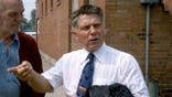 Jimmy Hoffa talks with people on a street.