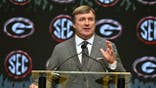 Kirby Smart, head coach of the Georgia Bulldogs, speaks at a podium during a press conference.