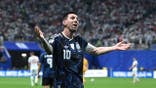 Lionel Messi celebrates to fans in a stadium.