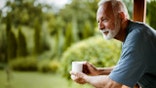 Smiling mature man enjoying in morning coffee on a terrace.