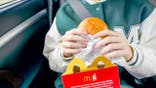 A child holds a McDonald's sandwich.