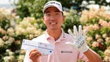 Michael Kim poses with his scorecard after shooting a 59 at the 3M Open.