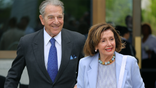 Former House Speaker Nancy Pelosi and her husband, Paul Pelosi, smile as they arrive together at an event.