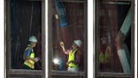 Workers inspecting buckled support beams inside a New York City high-rise
