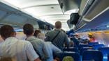 People standing to get off the plane.