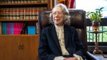 Pauline Newman sitting at her office desk surrounded by books and documents in Washington, D.C.