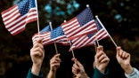 A group of people holding small American flags.