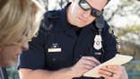 Police officer gives a woman a traffic ticket.