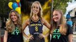 Brandi Kruse and fan pose with a Sophie Cunningham cutout.