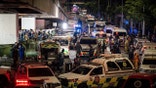 An ambulance is parked outside a bar after a massive fire broke out in Bangkok