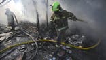 Ukrainian firefighters extinguish a fire at a market in Kyiv following a Russian missile strike.