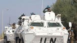 United Nations workers on a tank