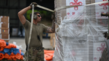 A U.S. soldier undoes wrapping on Chinese aid to Venezuela