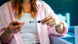Woman holds a BPC-157 peptide injection pen.