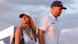 Wyndham Clark and Emily Tanner walk off the 18th green at Shinnecock Hills.
