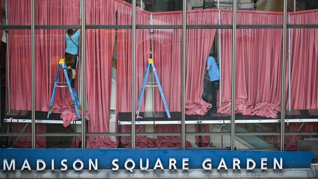 Red curtains are seen being put up inside Madison Square Garden