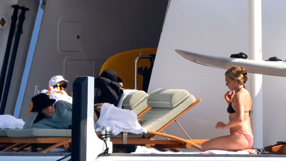 Cox and Aniston talking while lounging on vacation in Mallorca.