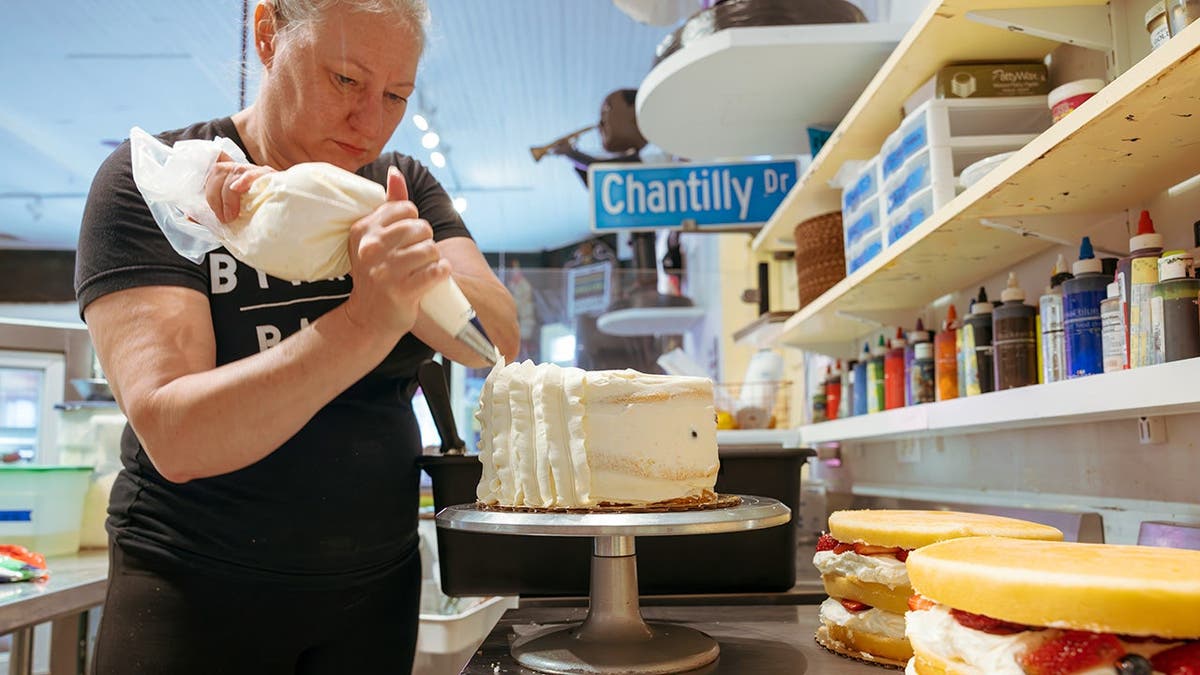 Chaya Conrad ices a Chantilly cake.