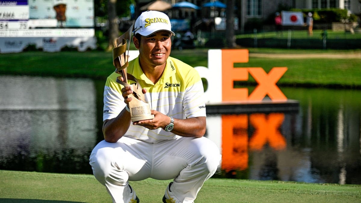Hideki Matsuyama poses with the trophy after winning the 2024 FedEx St. Jude Championship at TPC Southwind in Memphis, Tennessee.