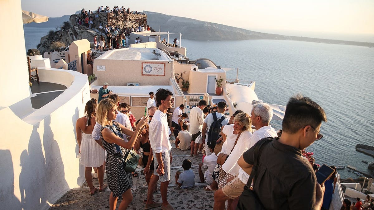 Tourists wait for sunset in Oia, Santorini.