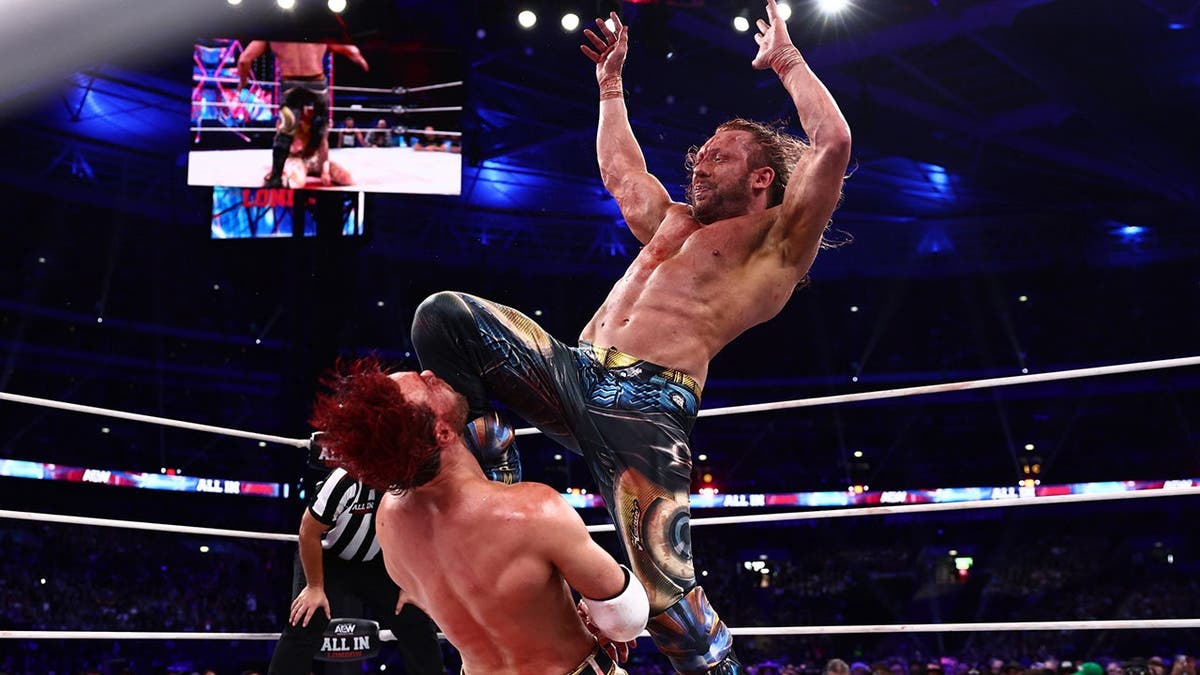 Kenny Omega hits a running knee