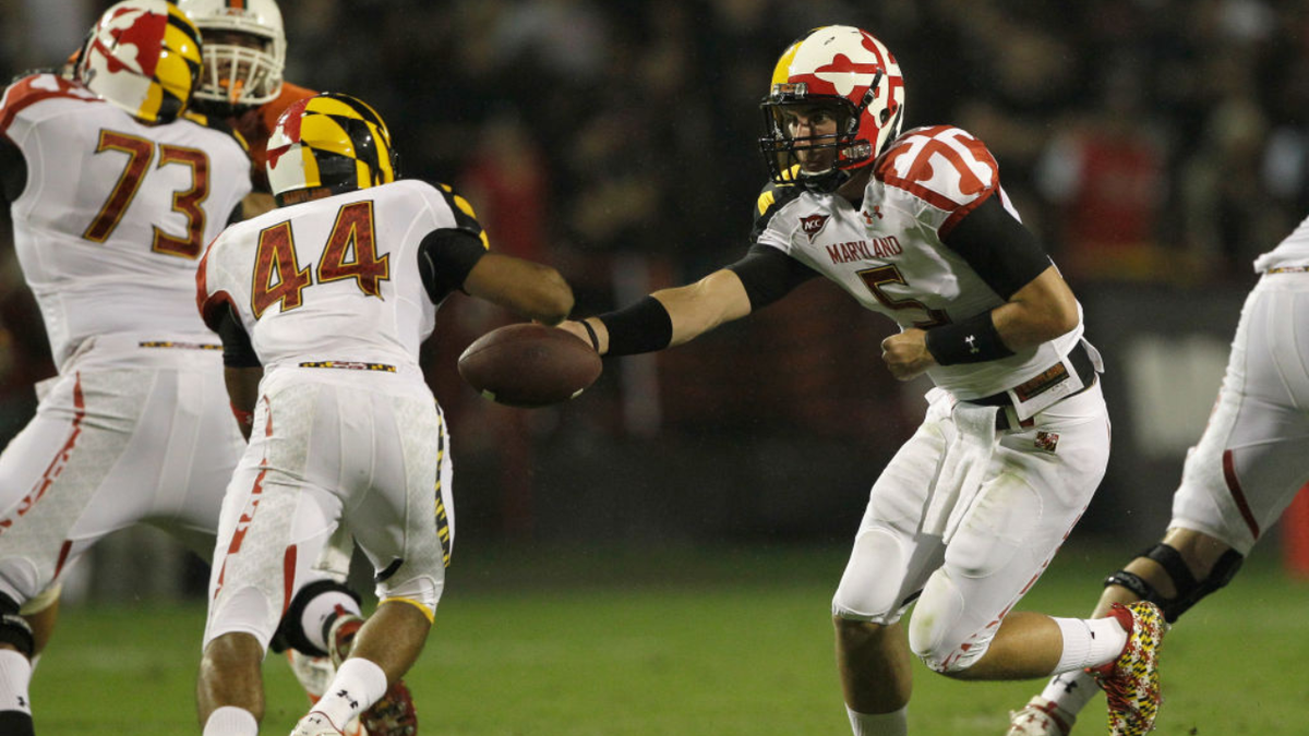 Danny O'Brien hands the ball off to Justus Pickett during a college football game.