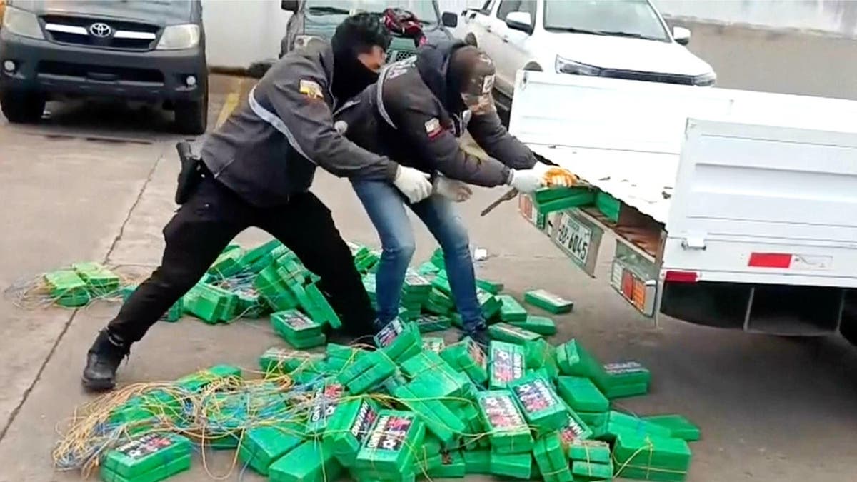 Agents removing cocaine bricks from truck bed