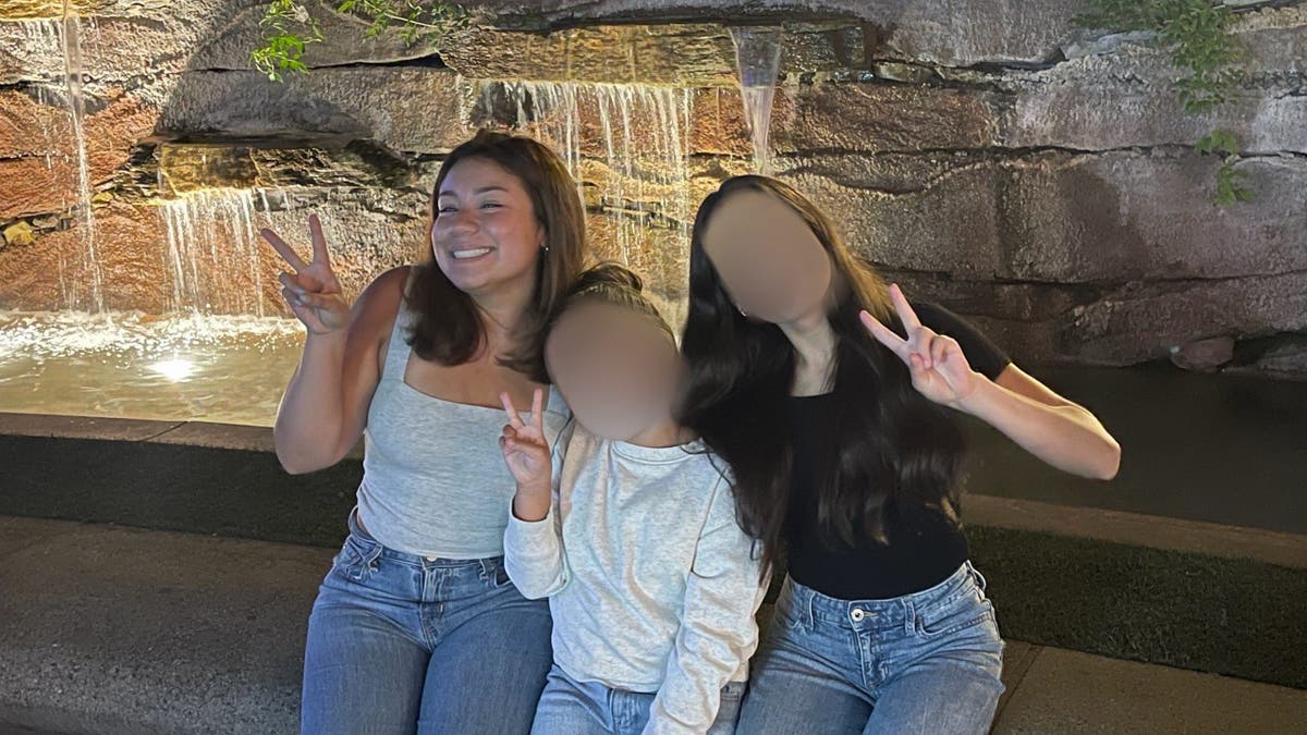 image shows Julie posing with two younger sisters.